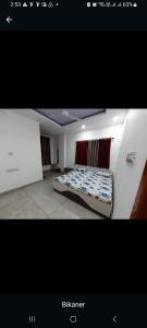 a bedroom with a bed in the corner of a room at VTP Guest House in Bikaner