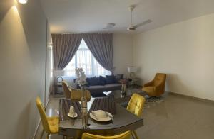 uma sala de estar com uma mesa e cadeiras amarelas em WAAFI LA CORNICHE RESIDENCE em Djibouti