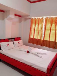 a bed in a room with red and yellow curtains at WJV INN BACOLOD in Bacolod