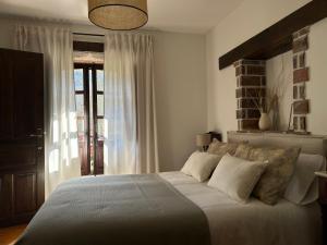 1 dormitorio con 1 cama grande con sábanas y almohadas blancas en Casa Arenas en Arenas de Cabrales