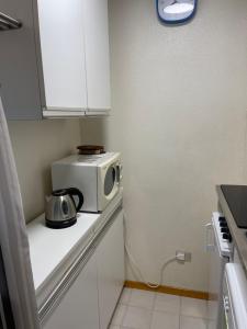 - un four micro-ondes installé au-dessus d'un comptoir dans la cuisine dans l'établissement Casa i Larici del Brenta, à Folgarida