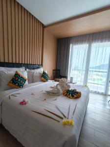 Un dormitorio con una gran cama blanca con flores. en Raja Hotel Kuta Mandalika Resort & Convention en Kuta Lombok