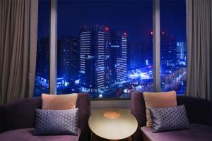 a room with a view of a city at night at W Chengdu in Chengdu