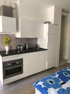 a kitchen with white cabinets and a black counter top at Modern city studio with own patio in Helsinki