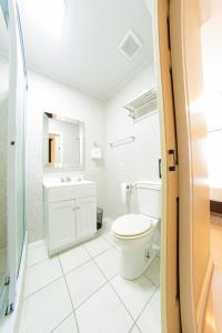a white bathroom with a toilet and a sink at Parc Rayne in Georgetown