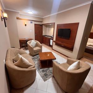 a living room with two chairs and a television at Comfort Eland Hotel in Arusha