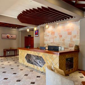 a bar in a restaurant with a stone wall at Comfort Eland Hotel in Arusha
