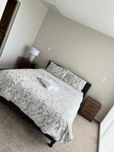 um quarto com uma cama com um edredão branco em 8 Ocean Rd em Auckland