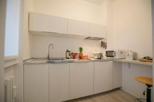 una cocina con armarios blancos y fregadero en Casa Del Lago - Happy Rentals, en Desenzano del Garda