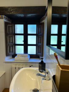 a bathroom with a sink and two windows at Casa Arenas in Arenas de Cabrales