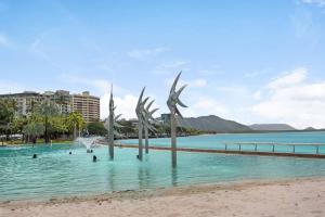 a group of people swimming in the water at a beach at Panoramic views 3BR Cairns City Apartment in Cairns