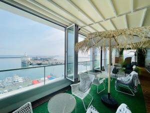 a balcony with a table and chairs and an umbrella at Stay Hostel in Sokcho