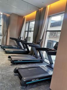 a row of treadmills in a gym with a window at Guus Hotel in Zengcheng