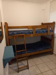 two bunk beds in a room with a ladder at SUNSET BEACH in Uvongo Beach