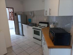 a kitchen with a stove and a refrigerator at SUNSET BEACH in Uvongo Beach
