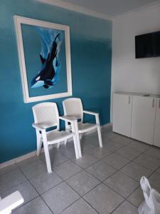 una habitación con 2 sillas y una foto de un delfín en SUNSET BEACH, en Uvongo Beach