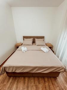 a bedroom with a large bed with two towels on it at Kiko apartmani LUX in Zrenjanin