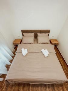 1 dormitorio con 1 cama con 2 almohadas en Kiko apartmani LUX, en Zrenjanin