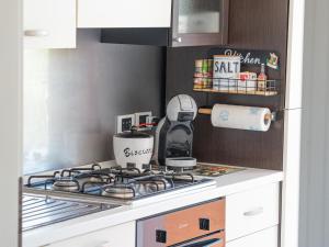 een keuken met een kookplaat en een oven bij Apartment Portorosa Residence in Torre Forte