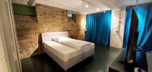 Zimmer im Loft في مانهايم: غرفة نوم بسرير وجدار من الطوب
