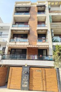 an apartment building with two garage doors in front of it at Greenleaf Apartment and Suites, Greater Kailash 1 in New Delhi