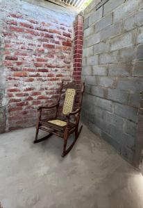 リバスにあるHostal Brisas del Ometepeの煉瓦の壁に座るロッキングチェア