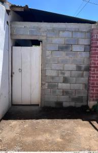 a brick garage with a white door and a brick wall at Hostal Brisas del Ometepe in Rivas