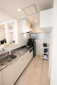 a kitchen with white cabinets and a sink at 大山町戸建 in Tokyo