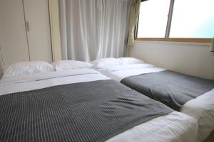 a row of beds in a room with a window at 大山町戸建 in Tokyo