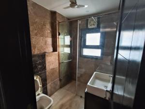 e bagno con servizi igienici, doccia e lavandino. di Greenleaf Apartment and Suites, Greater Kailash 1 a Nuova Delhi