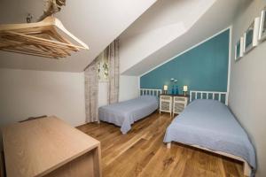 - une chambre avec 2 lits et un mur bleu dans l'établissement Apartments Marijin Dvor, à Splitska