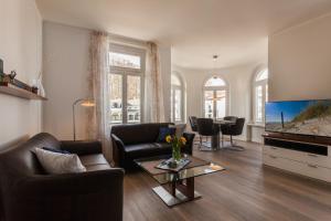 uma sala de estar com um sofá e uma televisão em Treibgut em Ostseebad Sellin