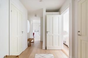 a hallway with white doors and a bedroom at Dinesen Collection Luxury Condos in Copenhagen +36 photos