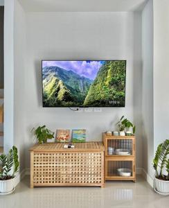 a living room with a television on a wall at Borbaimai home in Chiang Rai