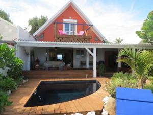 uma casa com uma piscina em frente em Villa Perle de Corail, les pieds dans l'eau em Saint-Paul