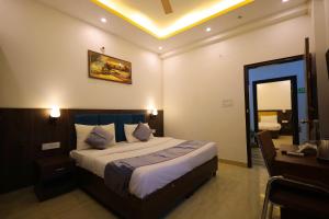 a bedroom with a bed and a desk and a mirror at Hotel Admire Stay in Noida