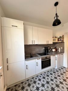 una cocina con armarios blancos y azulejos blancos y negros en Fachwerkhaus von 1894, Hahnenklee-Bockswiese Getaway, en Hahnenklee-Bockswiese