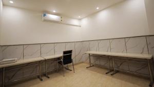 a waiting room with two tables and a chair at Hotel Admire Stay in Noida