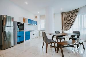 une cuisine et une salle à manger avec une table et un réfrigérateur dans l'établissement Ipoh Octagon Premium Suites by Verve, à Ipoh