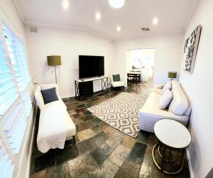 a living room with a couch and a tv at Beautiful and cozy home in Glenunga