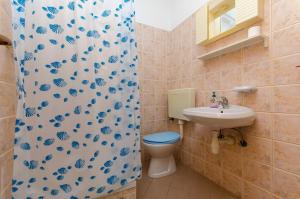ein Badezimmer mit Toilette, Waschbecken und Duschvorhang in der Unterkunft Apartments Sandra in Stomorska + 15 Fotos