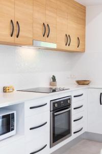 a kitchen with white cabinets and a stove at Bamboo Villa - Pet friendly luxury Villa next to Botanical Gardens in Edge Hill