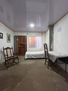 a room with two chairs and a bed and a window at Hostal Brisas del Ometepe in Rivas