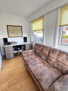 una sala de estar con un gran sofá marrón en Fachwerkhaus von 1894, Hahnenklee-Bockswiese Getaway, en Hahnenklee-Bockswiese