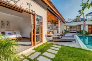 a villa with a swimming pool and a bedroom at Echo Beach Villa and Apartment in Canggu
