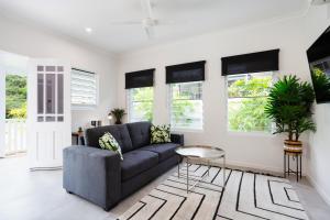 a living room with a couch and a table at Bamboo Villa - Pet friendly luxury Villa next to Botanical Gardens in Edge Hill