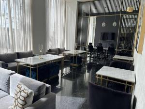 a living room with couches and tables and chairs at Lujoso Departamento en Angelópolis, Puebla. in El Gallinero