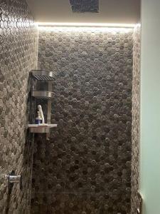 y baño con ducha y pared de azulejos. en Lujoso Departamento en Angelópolis, Puebla., en El Gallinero