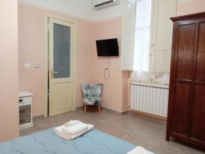 a room with a bed and a chair and a television at Piazza Verdi Liberty House in Lecce +187 photos
