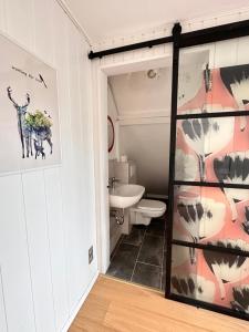 Un baño con una puerta de cristal con una pintura de una jirafa. en Fachwerkhaus von 1894, Hahnenklee-Bockswiese Getaway, en Hahnenklee-Bockswiese 25 fotos más